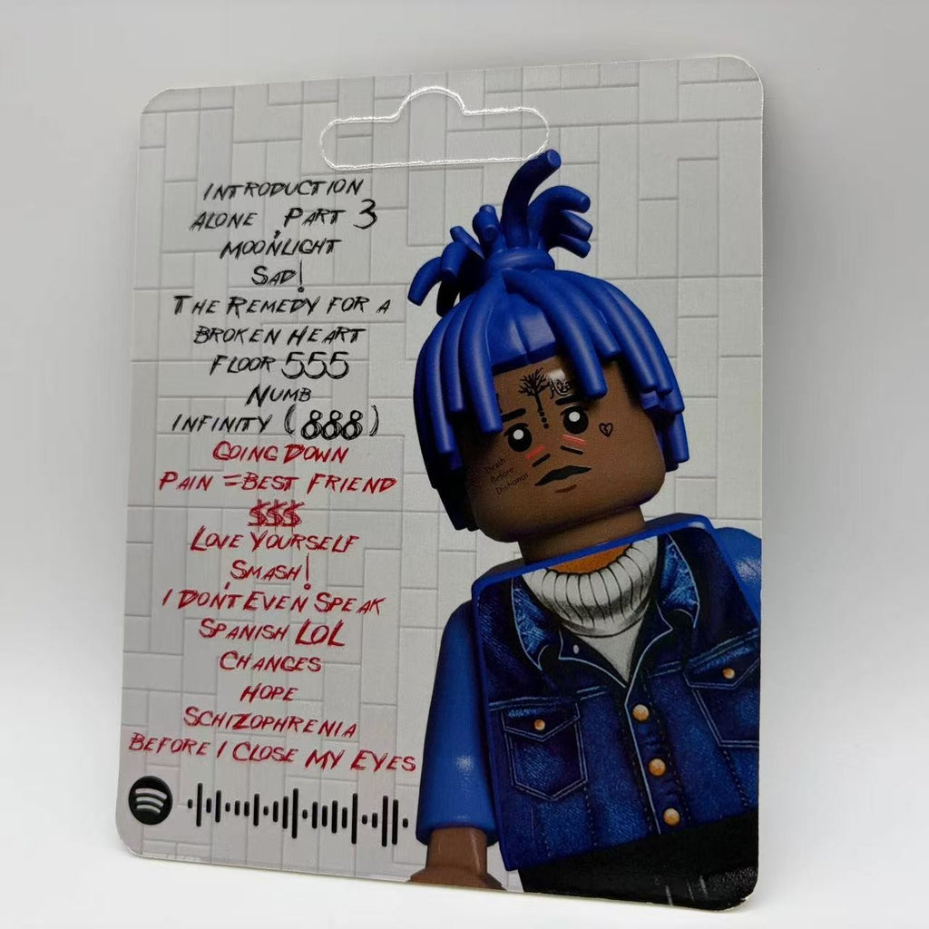 XXXTentacion custom minifigure with blue hair, tattoos, and detailed clothing on artistic backing card.