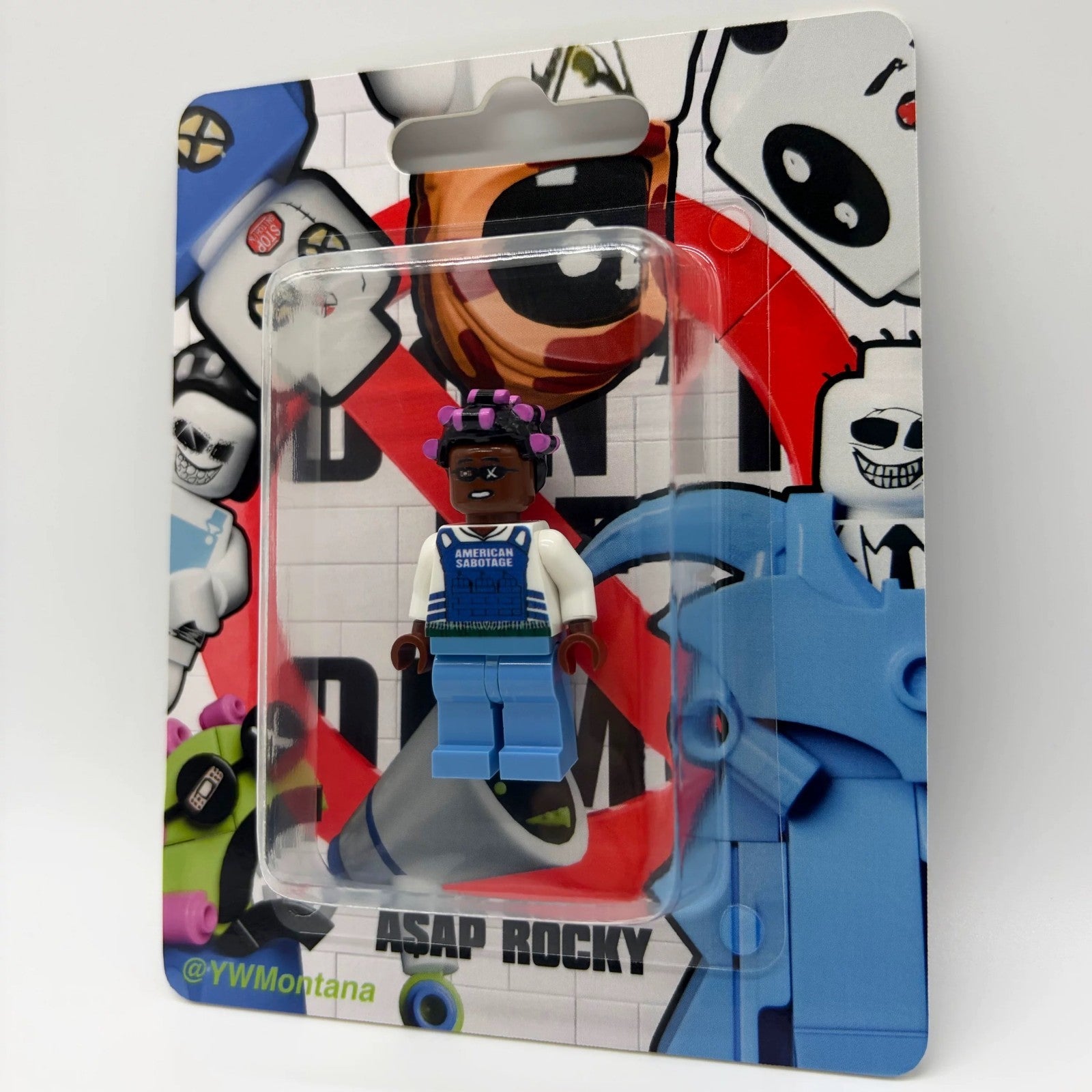 A$AP Rocky custom minifigure in blue "American Sabotage" vest with purple hair, blister pack display.