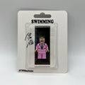 Mac Miller "Swimming" custom minifigure in a pink suit, displayed in collector's blister pack.
