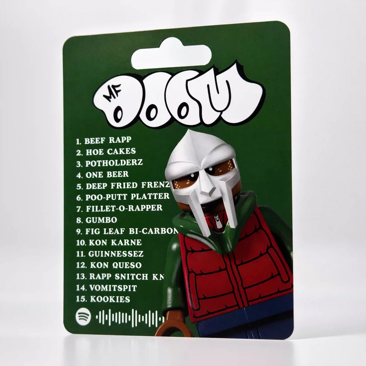 MF DOOM "MM...FOOD" custom minifigure with metallic mask, red and green outfit, collectible packaging.