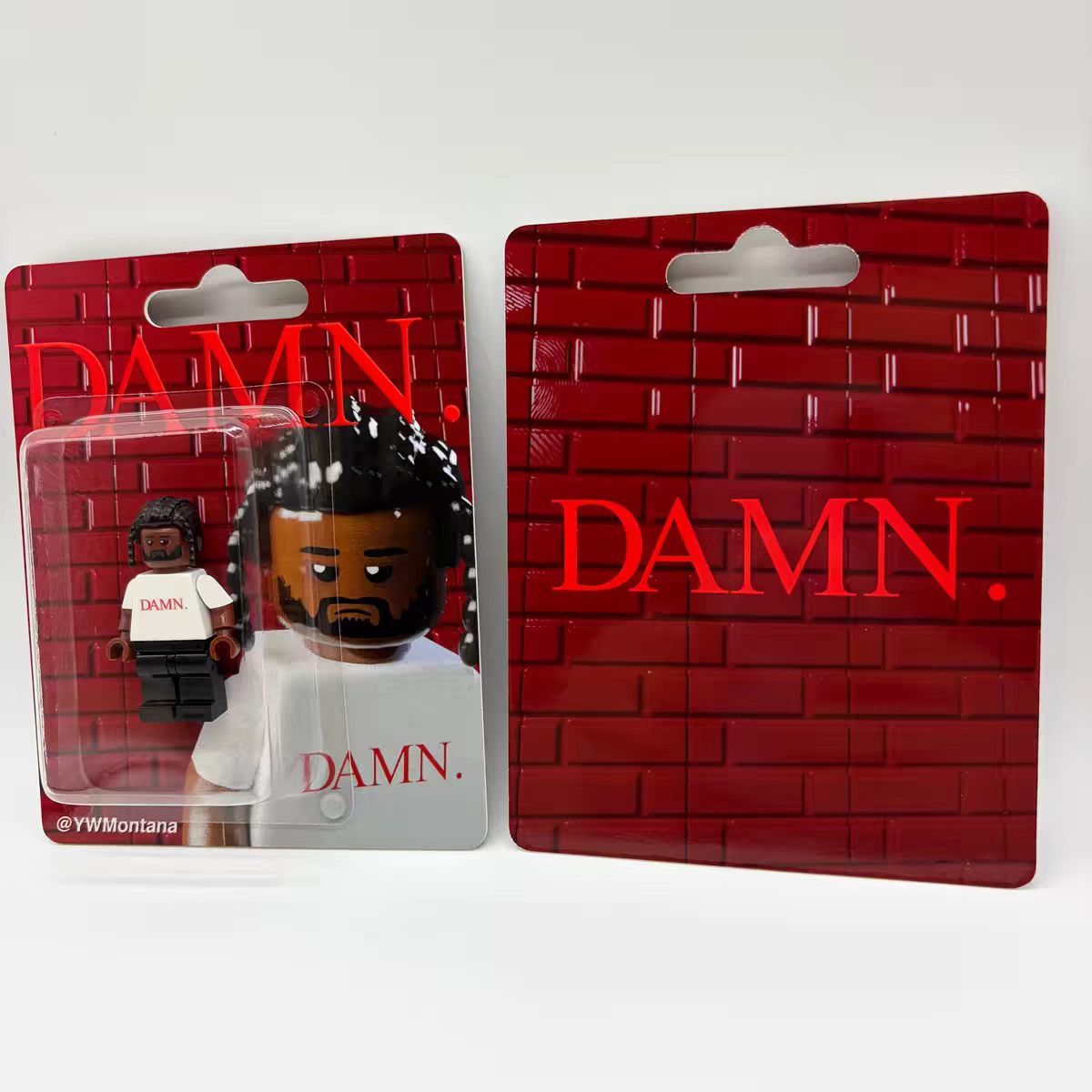 Kendrick Lamar "DAMN." custom minifigure, white tee, black trousers, red "DAMN." backdrop packaging.