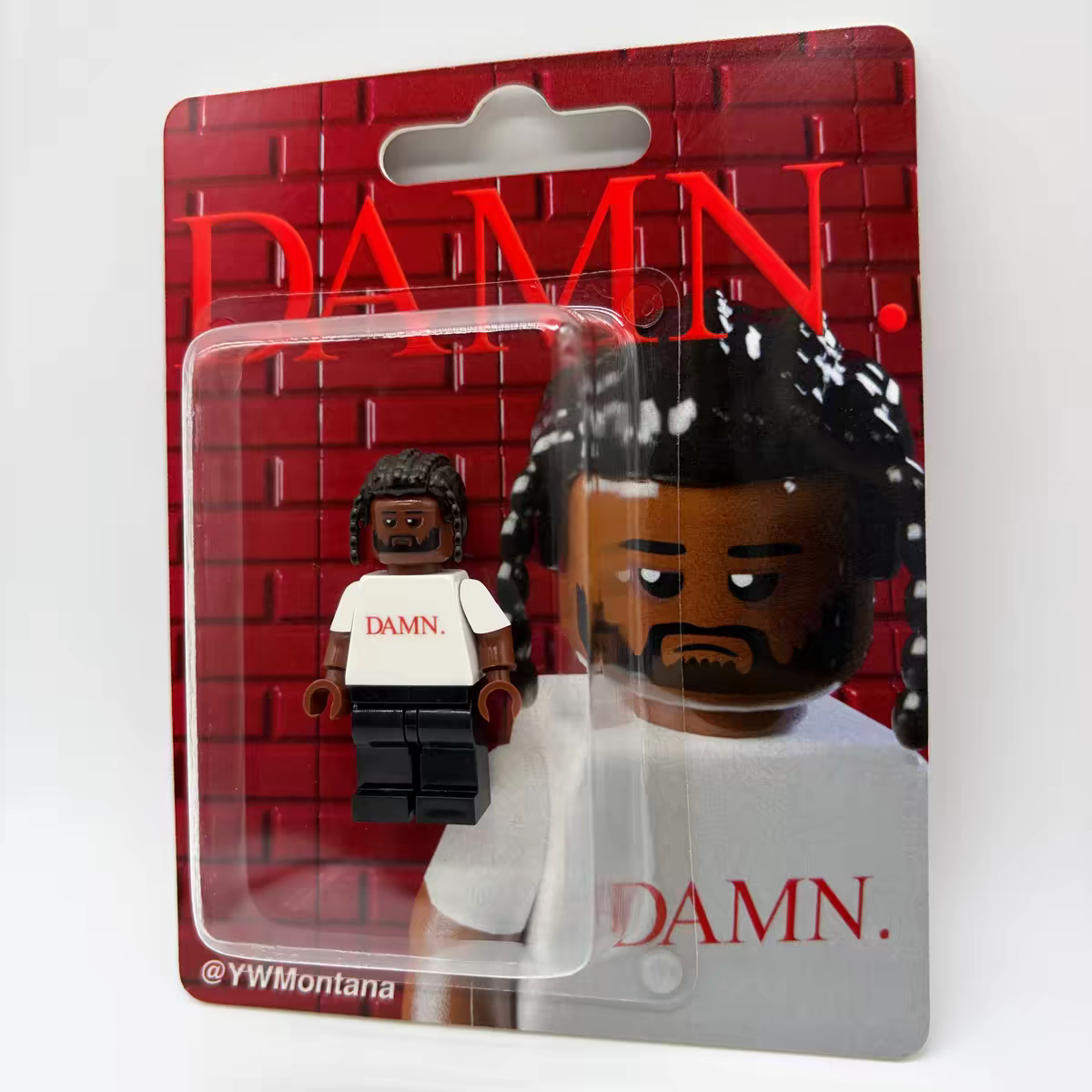 Kendrick Lamar "DAMN." album custom minifigure with braided hair in blister packaging, featuring red typography.